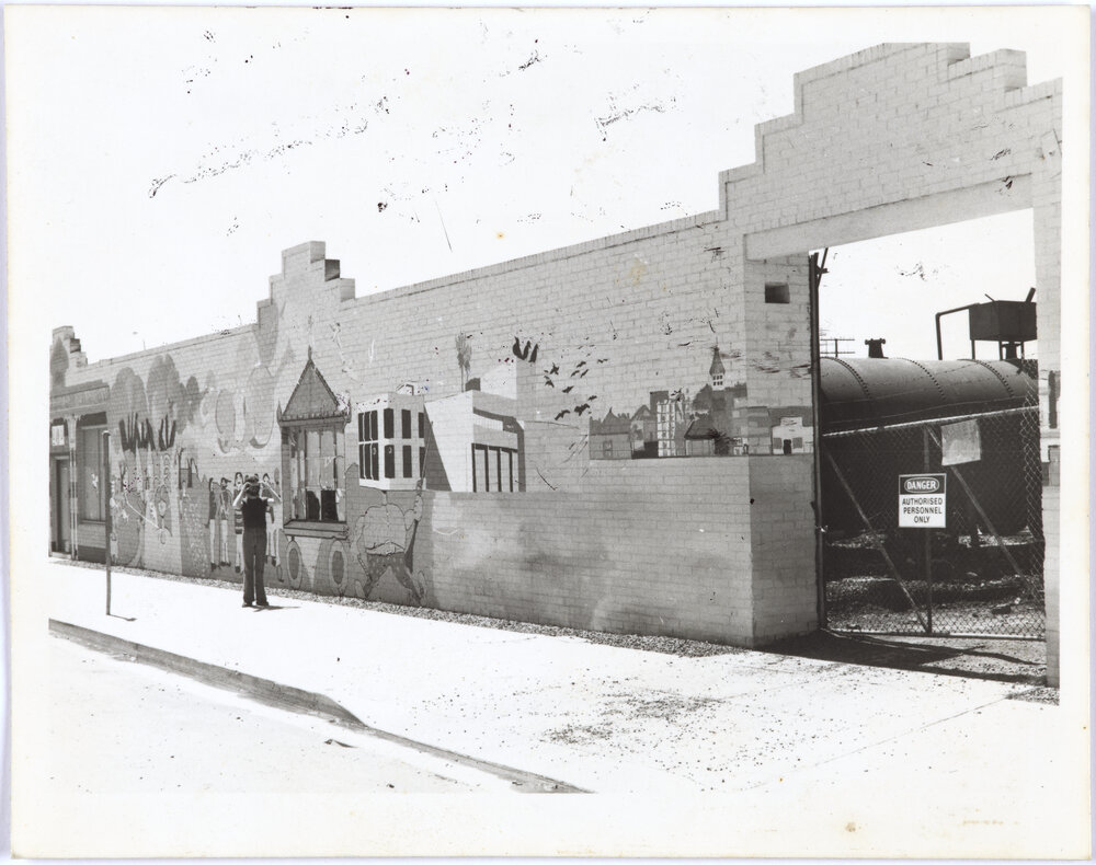 Mural on Gas Works brick wall, person standing in front