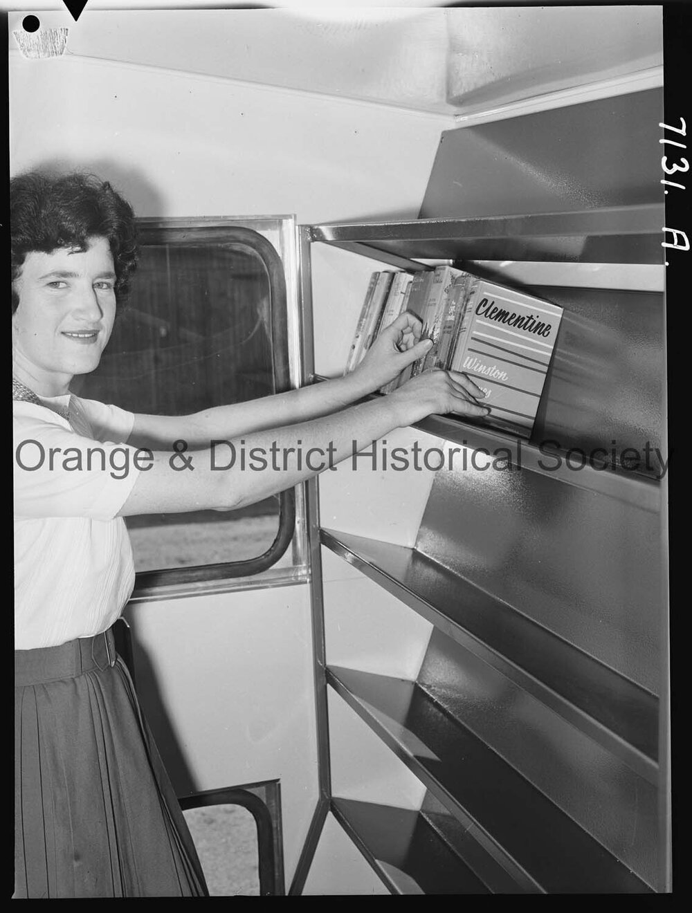 Librarian Joan Barry stacks books in new book mobile