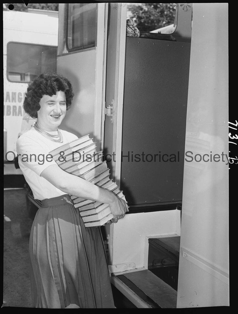 Librarian Joan Barry stacks books in new book mobile