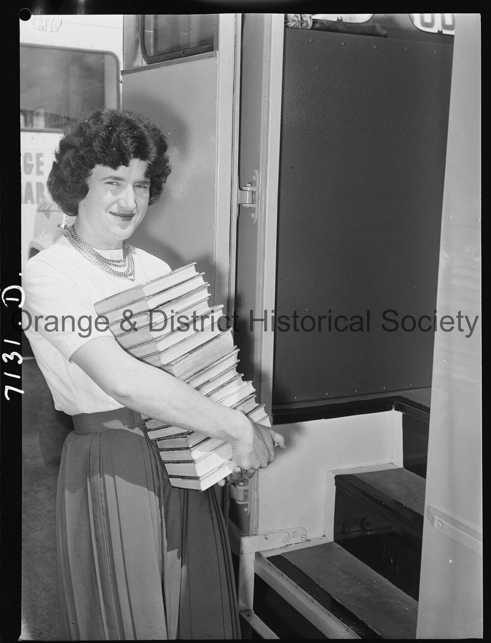 Librarian Joan Barry stacks books in new book mobile