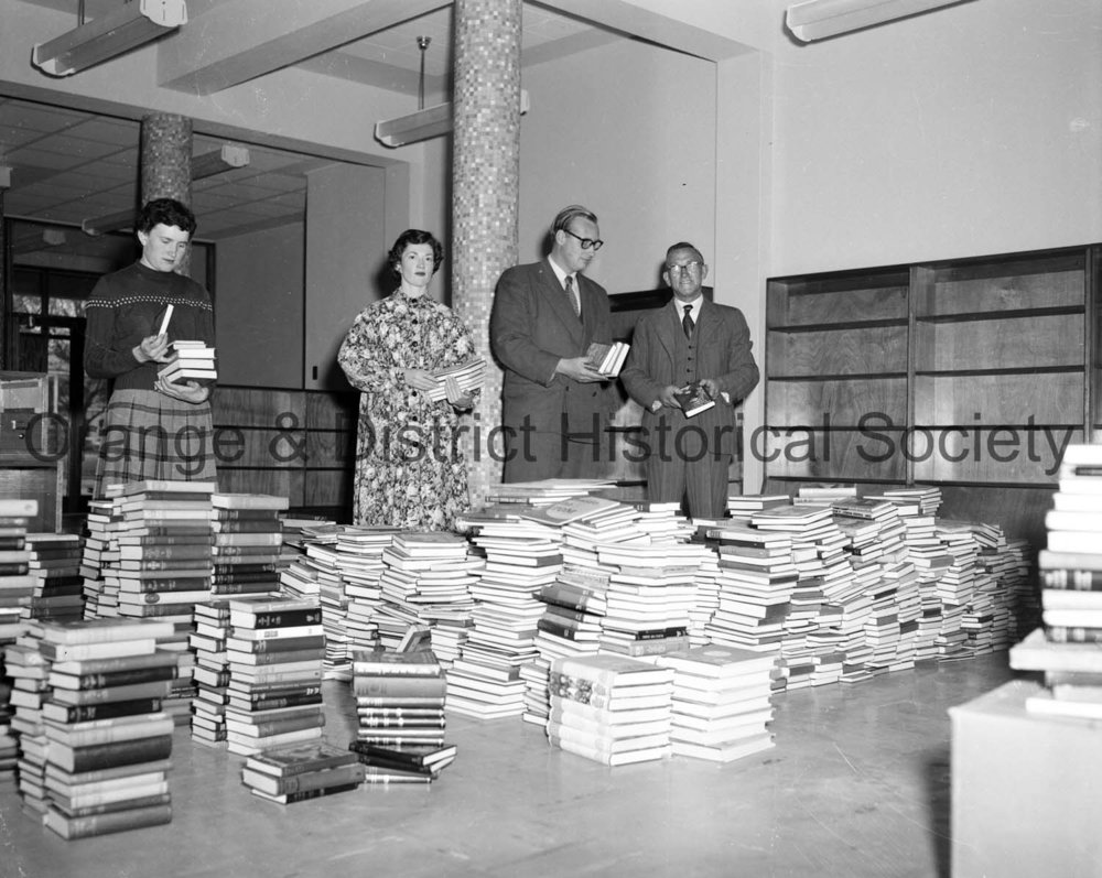 Judy Nicholas and others putting books in Library