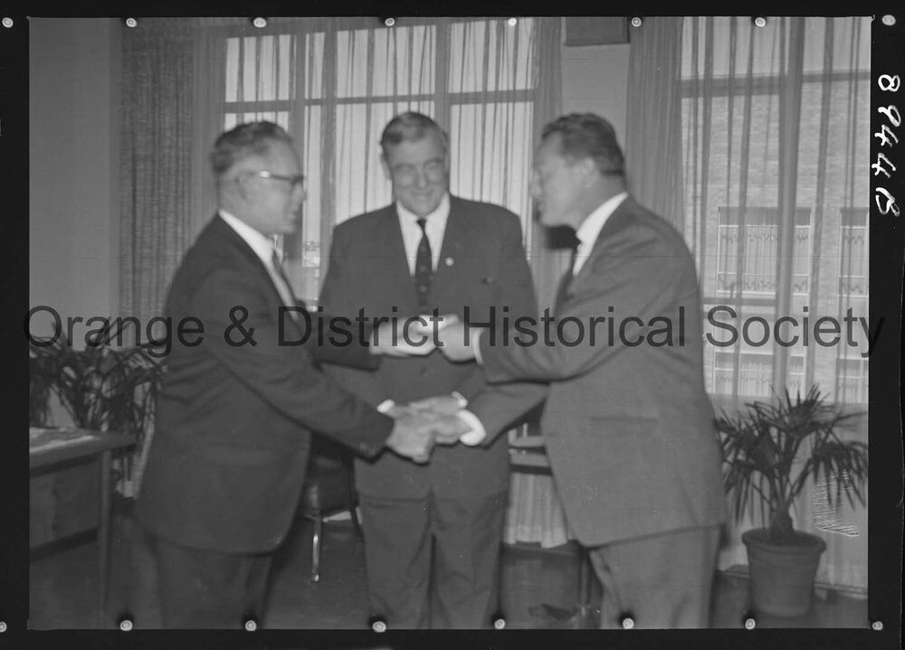 Sir Charles Moses watches while Mr C Spencer hands cheque to Mr F Pritchard