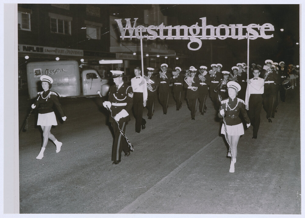 Emmco apprentices Bill Young and Bob Fabry proudly carry the Westinghouse banner along Summer Street, Orange