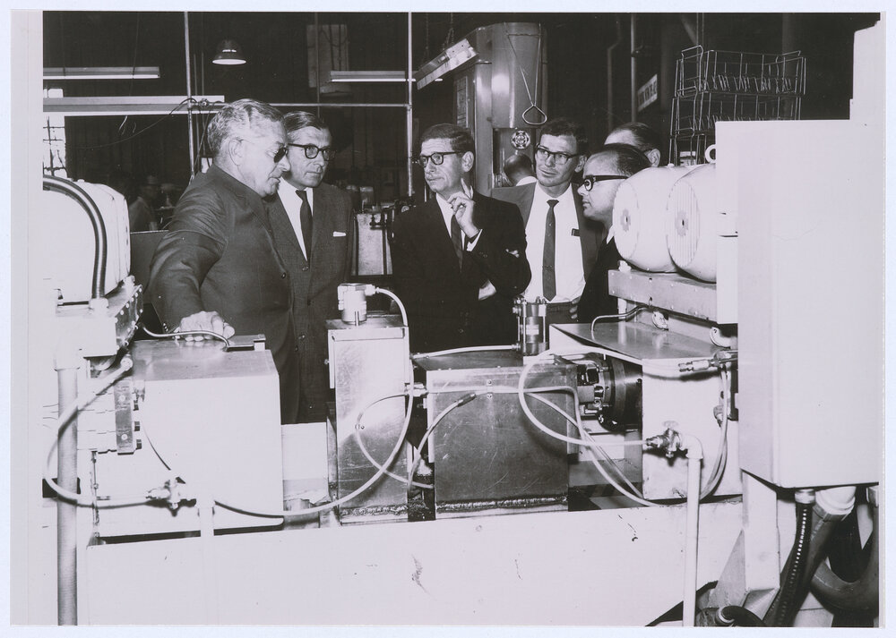 Email Managing Director Sir Alvin Burton-Taylor and Director Sir Peter Finley discuss production with Superintendent of Sealed Units Bob Stevenson, Sealed Unit Engineer Lance Sykes and Engineering Manager John Stephens.