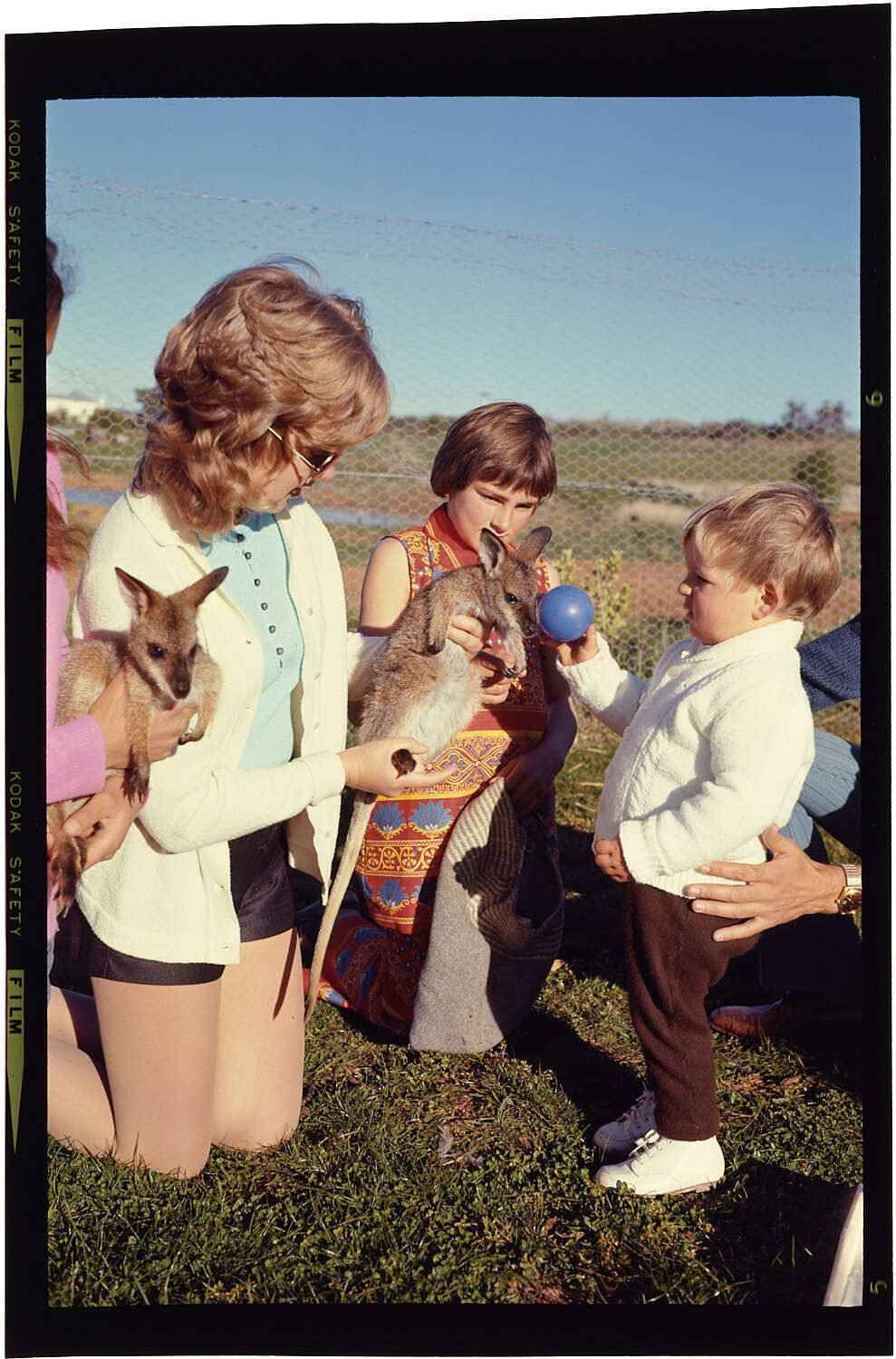 Woman and two children with two small wallabies