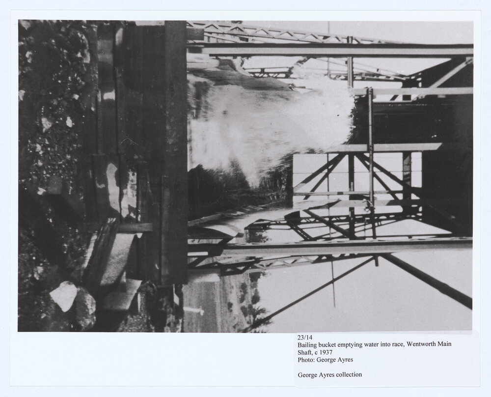 Bailing bucket emptying water into the race