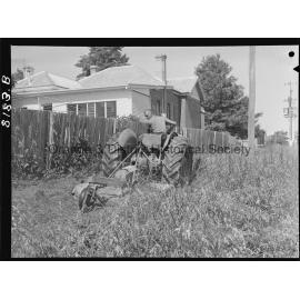 Mr Miller, OCC Works Depot employee cutting long grass in West Orange