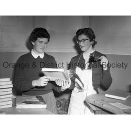 City librarian Joan Barry and Judy Nicholas with library books