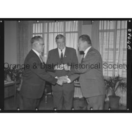 Sir Charles Moses watches while Mr C Spencer hands cheque to Mr F Pritchard