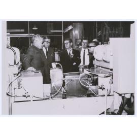 Email Managing Director Sir Alvin Burton-Taylor and Director Sir Peter Finley discuss production with Superintendent of Sealed Units Bob Stevenson, Sealed Unit Engineer Lance Sykes and Engineering Manager John Stephens.