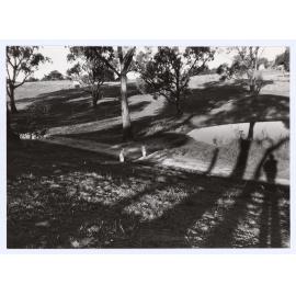 Twin girls playing next to a dam in the Orange Botanic Gardens.