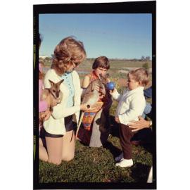 Woman and two children with two small wallabies
